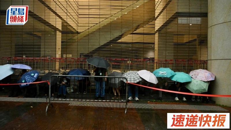 有近百名市民排队，躲在法院外有瓦遮头处。